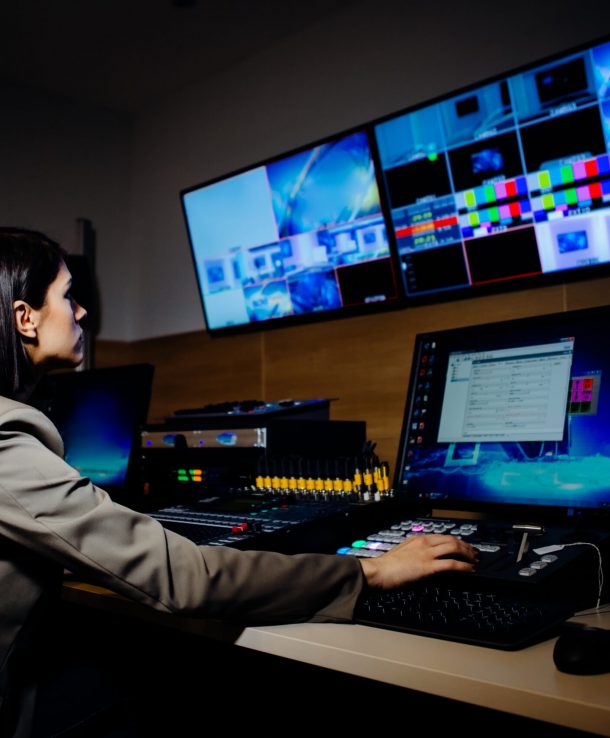 Female TV director control editing room in television studio.Operating vision mixer console equipment in a broadcast panel gallery.Realtime graphic engineer editor.Breaking news headline.Live stream